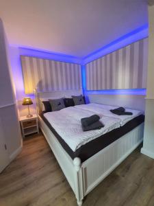 a bedroom with a bed with blue lights on it at Reinhardshäusle Pension & Wellness in Reinhardshausen