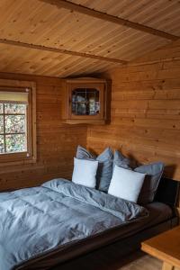 a bedroom with a bed in a log cabin at Hüttenzauber im Naturpark Altmühltal in Greding