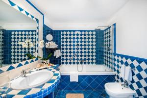 a blue and white bathroom with a tub and a sink at Grand Hotel Tritone in Praiano