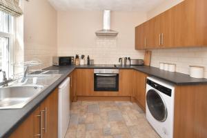 a kitchen with a sink and a washing machine at The Sutherland Arms in Stoke on Trent