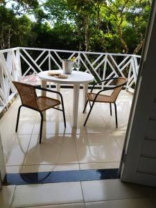 - Balcón con mesa blanca y 2 sillas en Vila Mulungu Casa, en Mulungu
