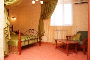 a bedroom with a bed and a table and a chair at Academia Hotel in Kurgan