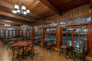 restauracja z drewnianymi stołami, krzesłami i oknami w obiekcie Best Western Plus French Quarter Courtyard Hotel w Nowym Orleanie
