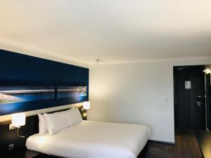 sypialnia z białym łóżkiem i niebieską ścianą w obiekcie Crowne Plaza Birmingham City, an IHG Hotel w Birmingham