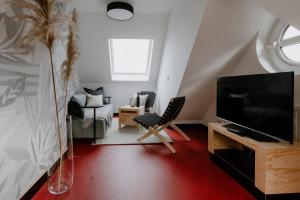a living room with a television and a couch at Appartement Am Salzbergtal in Wernigerode