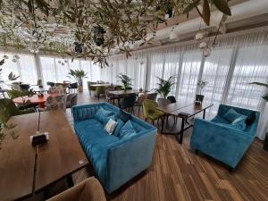 SPA Hotel Galera في كييف: غرفة معيشة مع أريكة زرقاء وطاولات