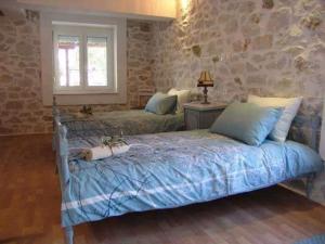 um quarto com 2 camas e uma parede de pedra em Villa Valia em Skala Kallirachis