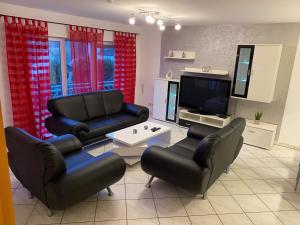 a living room with two chairs and a tv at Ferienwohnung Winkler in Lahnstein bei Koblenz am Rhein in Lahnstein