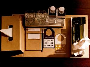 a box with glasses and a sign that reads please do not disturb at Gulliver's Tavern Hotel in Bangkok