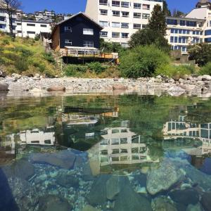 um reflexo de um edifício numa massa de água em Berkana hostel Bariloche em San Carlos de Bariloche