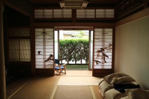 a room with an open door to a room with a couch at Lacomaゲストハウス in Esumi