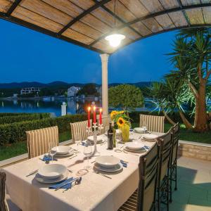 a table with candles and plates and chairs on a patio at Holiday Home Lovište in Lovište