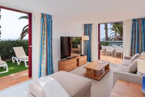 ein Wohnzimmer mit einem Sofa und einem TV in der Unterkunft Drago Residence by Upper Luxury Housing - Parque Santiago in Playa de las Americas