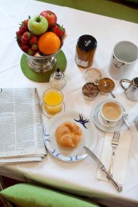 a table with a plate of food and a bowl of fruit at Hotel Schwalbe in Vienna