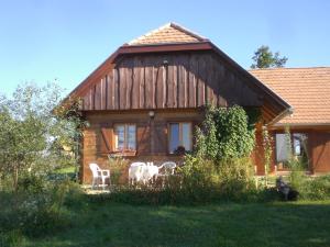 a house with two white chairs in front of it at Naturpark Ferienhaus in Szalafő