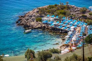 a beach with a bunch of umbrellas and the ocean at Hamarat Otel in Kaş