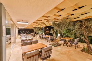 a restaurant with tables and chairs and trees at Hamarat Otel in Kaş