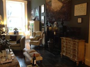 a living room with a couch and chairs and a dresser at A Room in the City - West in Edinburgh