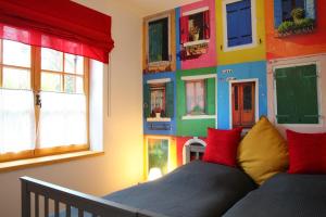 a bedroom with a colorful wall with windows at Döme's Point in Leányfalu