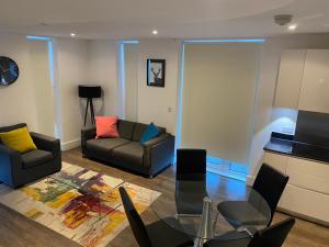 a living room with a couch and a table at HIGH VIEW TWO BEDROOM APARTMENT IN WOOLWICH in London