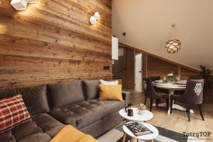 sala de estar con sofá y mesa en Apartament Stary Drewniany Białka Ski Resort, en Białka Tatrzanska