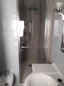 a bathroom with a shower and a toilet and a sink at Hotel Aranda in Aranda de Duero
