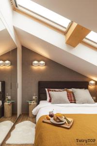 sypialnia z łóżkiem z tacą z jedzeniem w obiekcie Apartament Stary Drewniany Białka Ski Resort w mieście Białka Tatrzanska