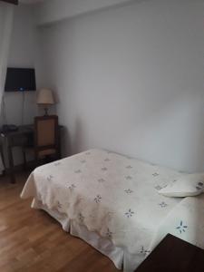 a bed room with a white bedspread and pillows at Hotel Aranda in Aranda de Duero