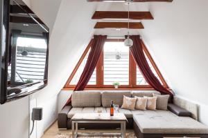 a living room with a couch and a table at Apartamenty Osada Gubałówka Zakopane in Zakopane