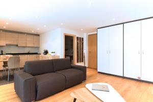 sala de estar con sofá y cocina en Meric Apartment, en Zermatt