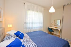 Un dormitorio con una cama azul y blanca y un escritorio en visit baltic - Rezydencja Sienkiewicza Nautical apartment en Świnoujście