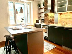 a kitchen with green cabinets and a white counter top at City Home Finland Ratina - Spacious Studio with Own SAUNA and Great Location Next to Uros Live Arena in Tampere