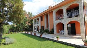 Un edificio con césped delante. en Apartment Prosinečki, en Malinska