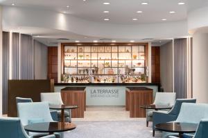 a waiting room with tables and chairs and a counter at Sofitel London Gatwick in Horley