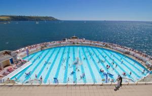 - une grande piscine avec des personnes à l'eau dans l'établissement Stunning townhouse at Plymouth Hoe, à Plymouth