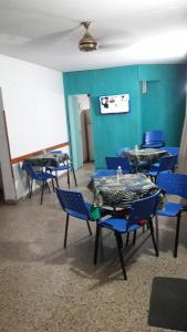 Habitación con mesas azules y sillas azules. en Residencial Ariand en Santa Rosa de Calamuchita