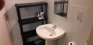 莱昂斯-达赫雷Appartement meublé vue/mer的浴室设有白色水槽和黑色架子。