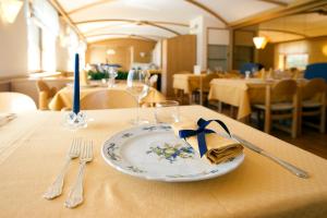 ein Teller mit einer blauen Kerze auf einem Tisch in der Unterkunft Hotel Posta in Sappada