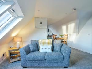 a living room with a blue couch and a table at Monkstadt No 9 - Pretenders Escape in Monkstadt