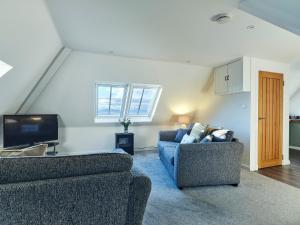 een woonkamer met 2 banken en een tv bij Monkstadt No 9 - Pretenders Escape in Monkstadt