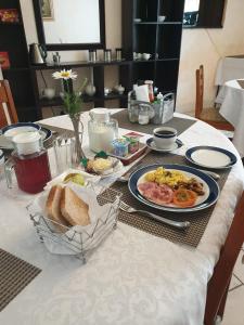 una mesa con platos de comida y pan. en Casa De Jardim Guesthouse, en Centurion