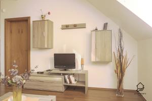 a living room with a tv on a table at TATRYSTAY Apartment C3 in Veľká Lomnica