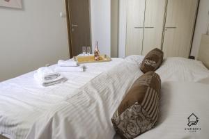a white bed with two pillows on top of it at TATRYSTAY Apartment C3 in Veľká Lomnica