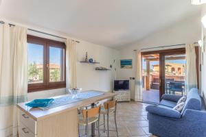 a kitchen and living room with a table and chairs at Villino il Faretto Spiaggia in Budoni