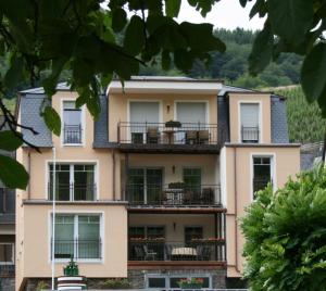 an apartment building with balconies and trees at Weingut Goeres in Briedel