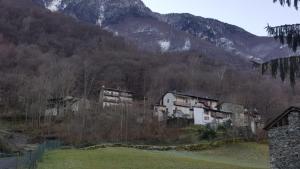 um grupo de edifícios em frente a uma montanha em Casa Ronit em Delebio