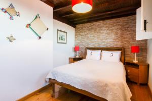 a bedroom with a bed and a brick wall at Casa Mont'Santo in Monsanto