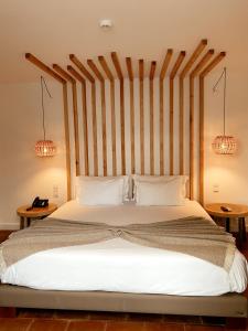 a bedroom with a bed with a canopy on top of it at ECORKHOTEL Evora in Évora