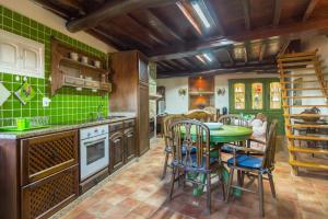 a kitchen with a table and chairs and green tiles at Casa Mont'Santo in Monsanto