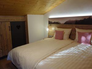 a bedroom with a large bed with red and white pillows at Doblerhof in Höslwang